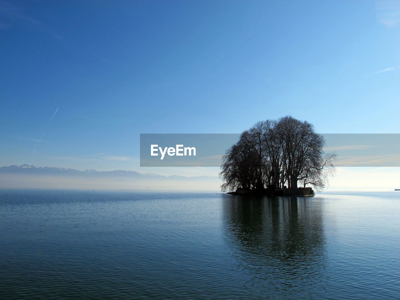 Scenic view of lake against clear blue sky