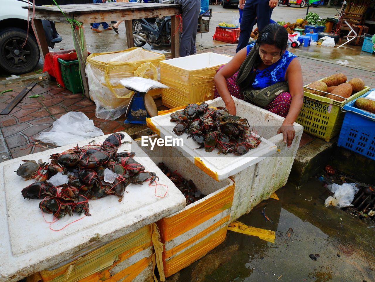 HIGH ANGLE VIEW OF PEOPLE AT MARKET STALL