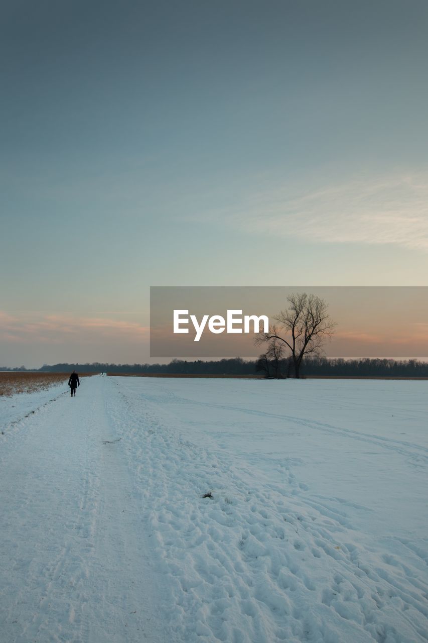 Scenic view of snow covered field against sky during sunset