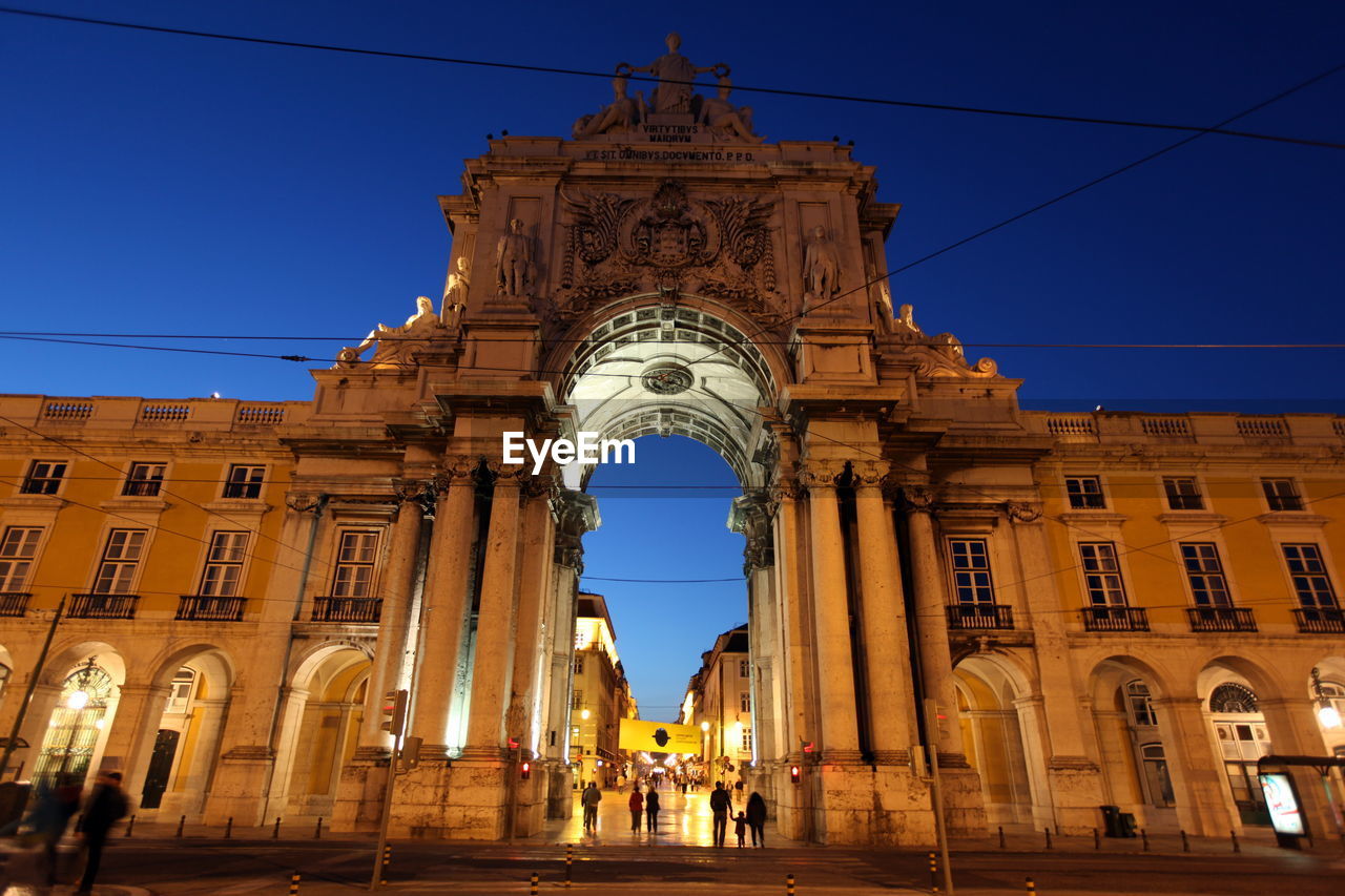 Low angle view of illuminated rua augusta arch in city