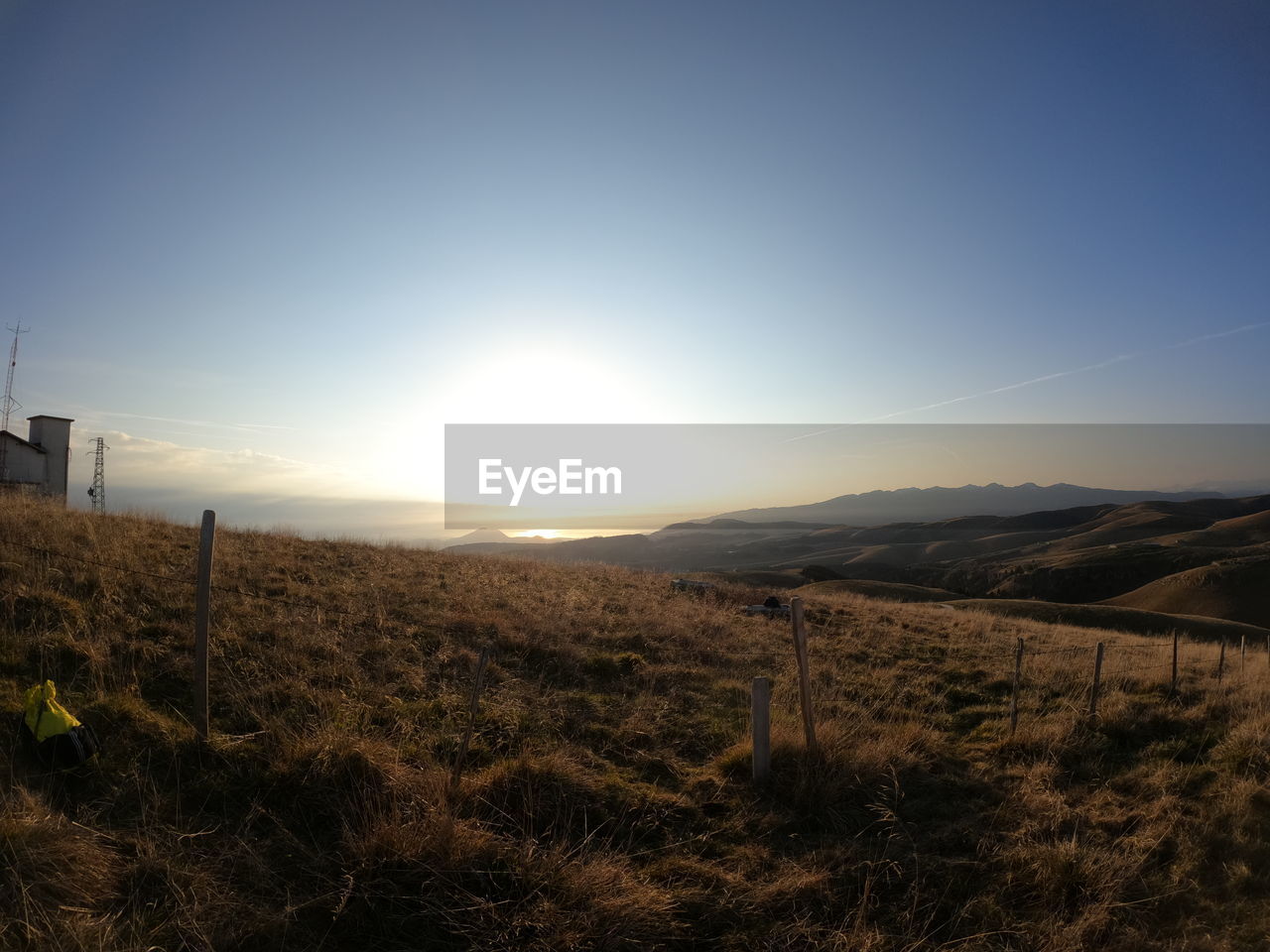 SCENIC VIEW OF GRASSY FIELD AGAINST SKY DURING SUNSET