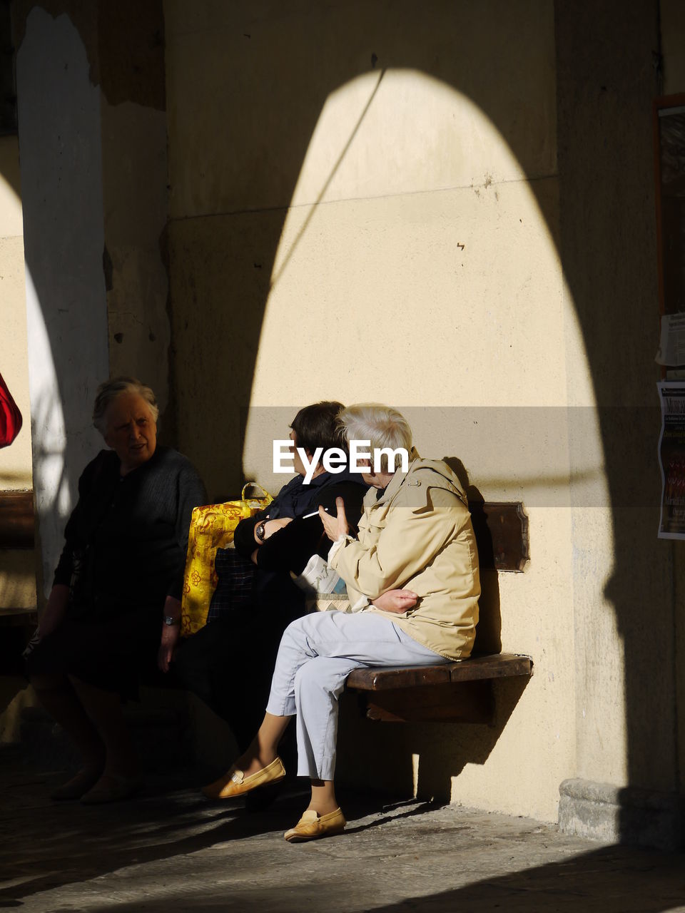 YOUNG WOMAN SITTING ON WALL