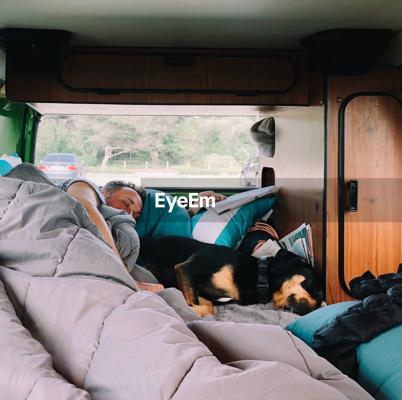 Man with dog sleeping in land vehicle