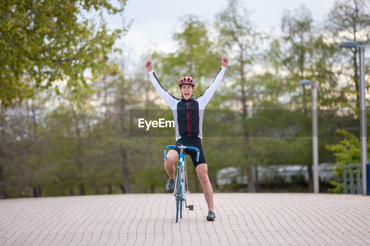 FULL LENGTH OF MAN RIDING BICYCLE ON ROAD