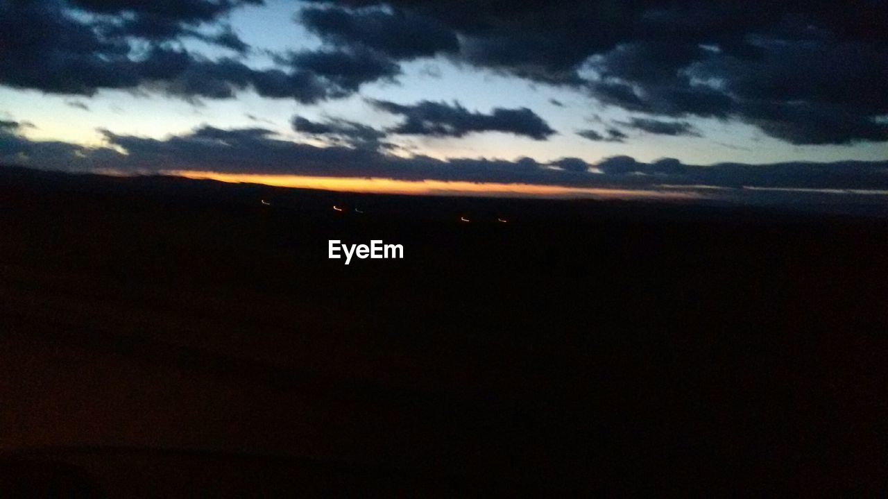 SCENIC VIEW OF SEA AGAINST CLOUDY SKY DURING SUNSET