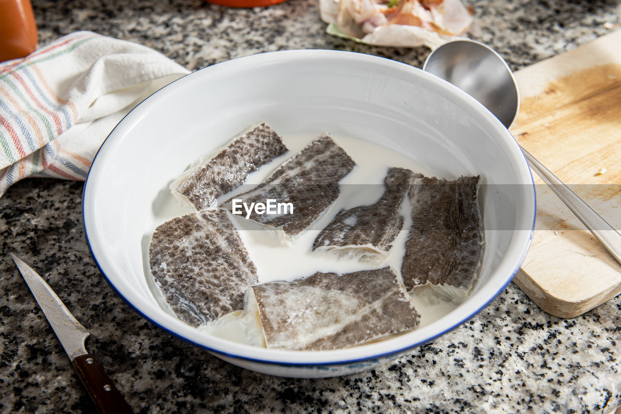 Bowl with cod soaking in milk.