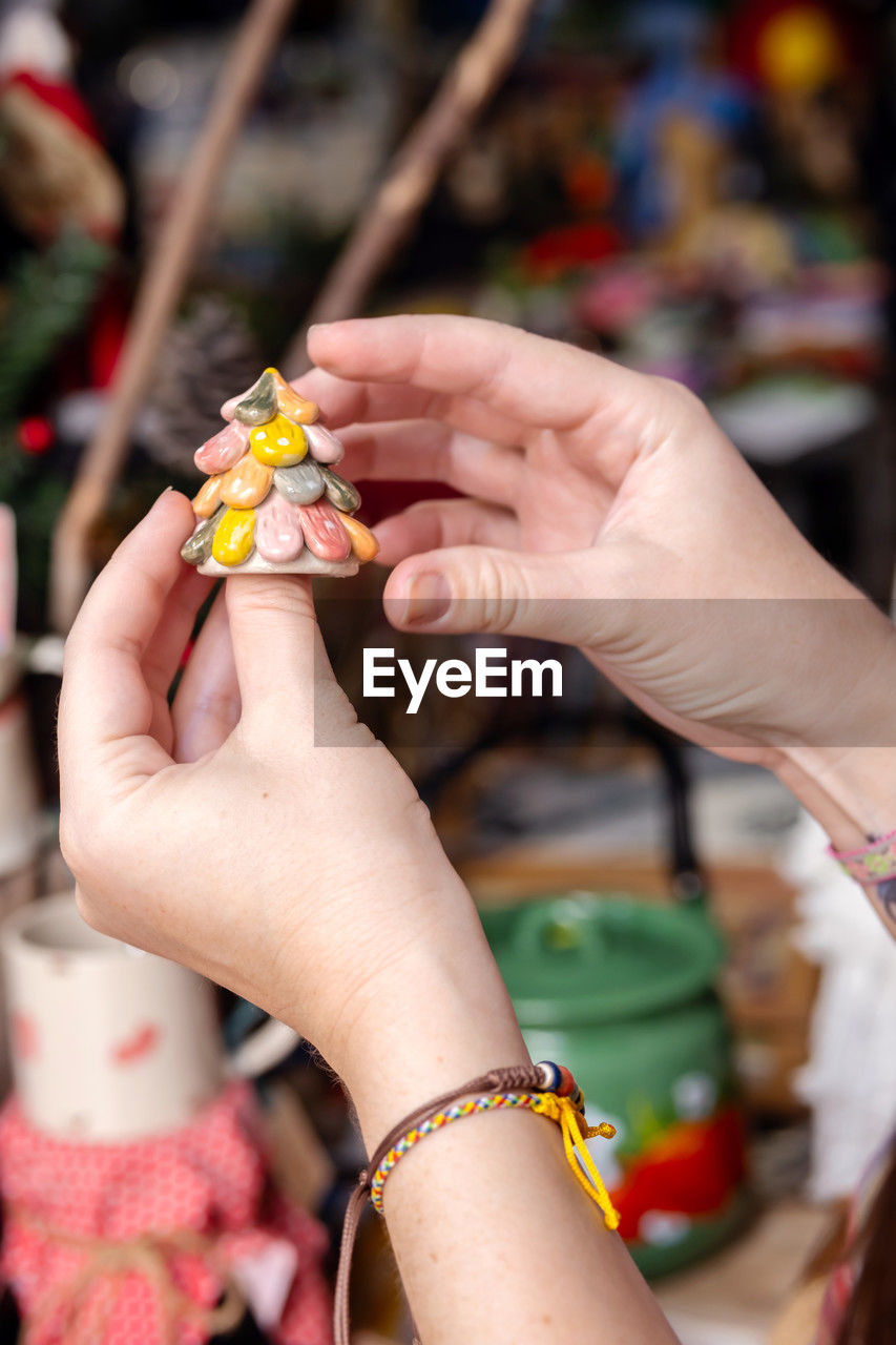 Woman choosing christmas gifts at small craft pottery store. wintertime holidays mood in tropic