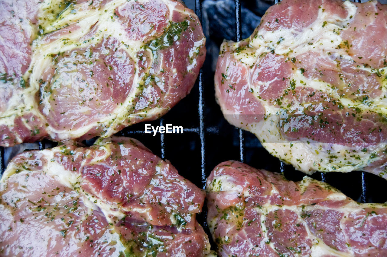 Directly above shot of pork cooking on barbecue grill