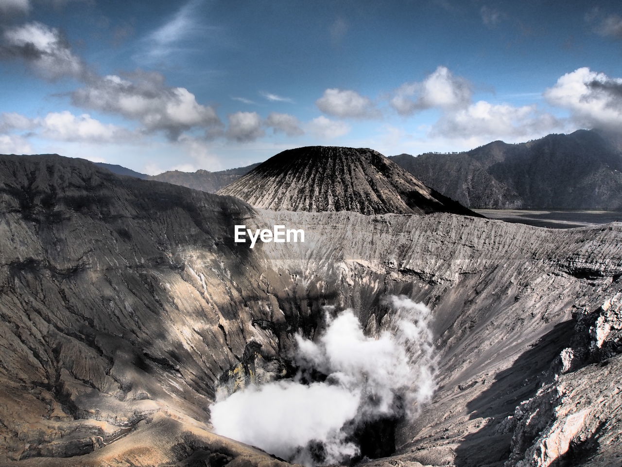 Scenic view of mountain range against cloudy sky