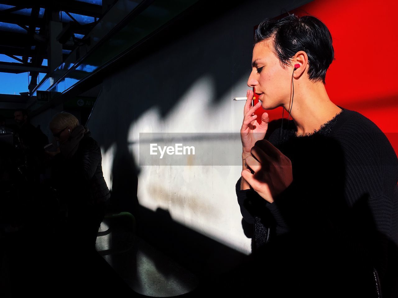 YOUNG WOMAN STANDING ON RED MIRROR