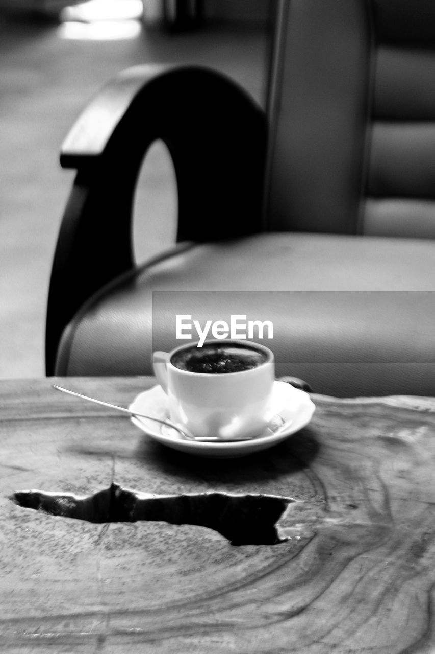 black, food and drink, mug, black and white, cup, drink, table, monochrome, coffee cup, coffee, still life photography, monochrome photography, white, indoors, refreshment, crockery, furniture, saucer, no people, focus on foreground, hot drink, wood, food, kitchen utensil, close-up, still life, spoon