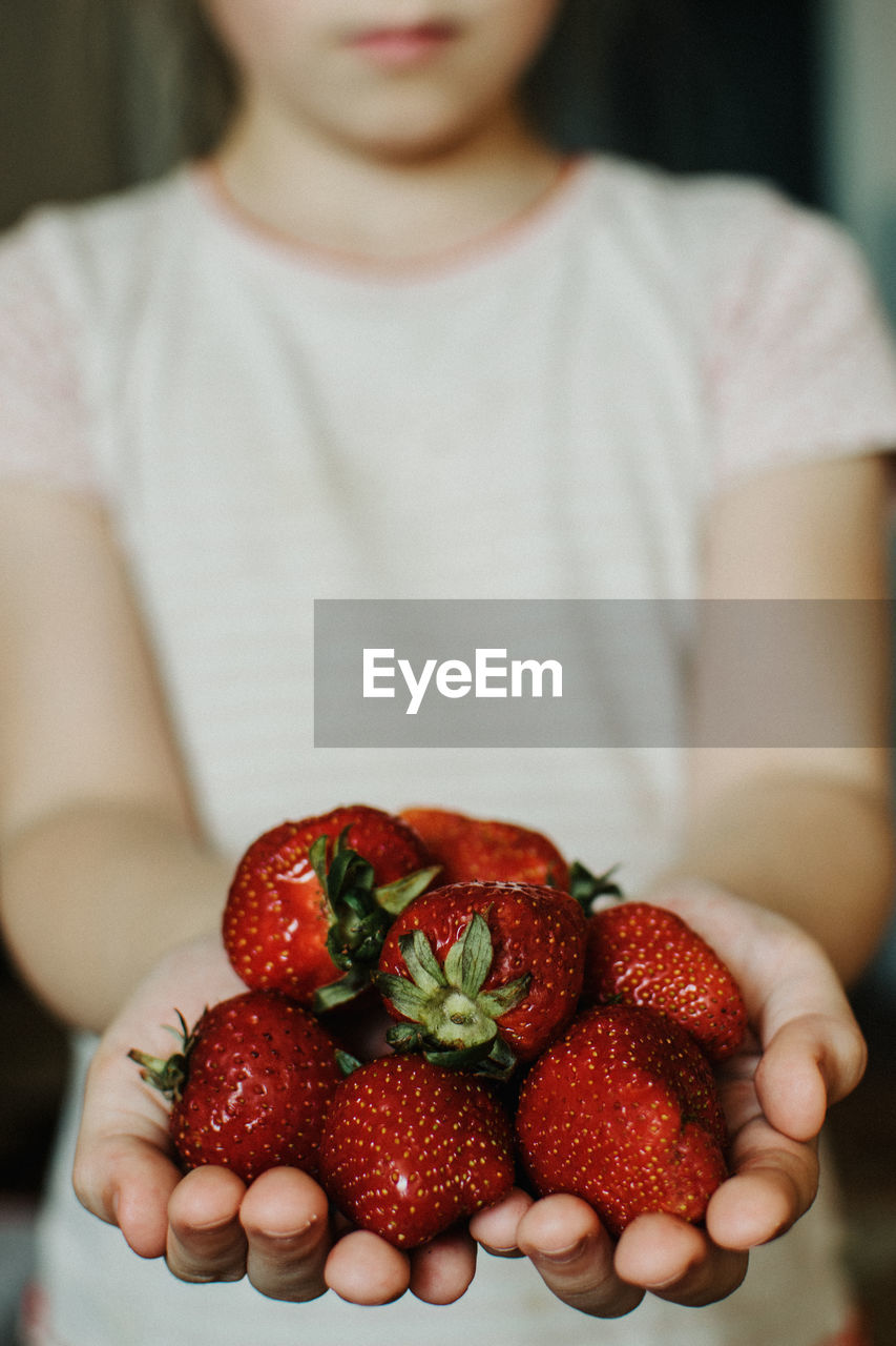 Close-up of hand holding strawberries