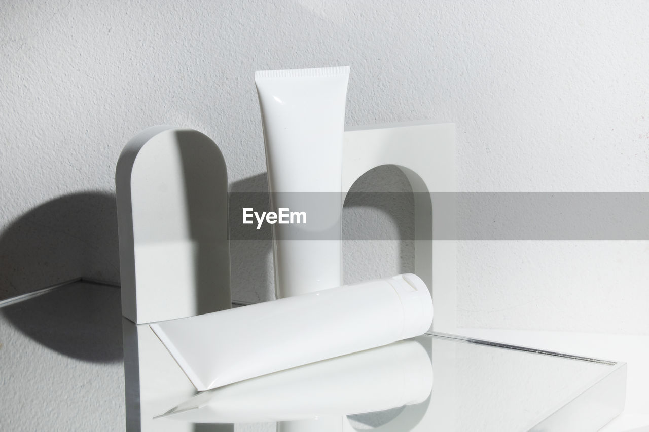Close-up of white objects on table against wall