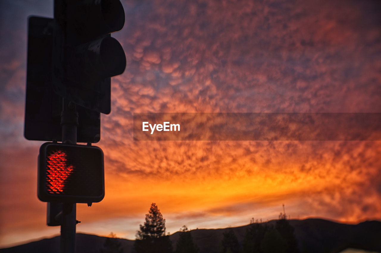 Low angle view of traffic signal against scenic sky