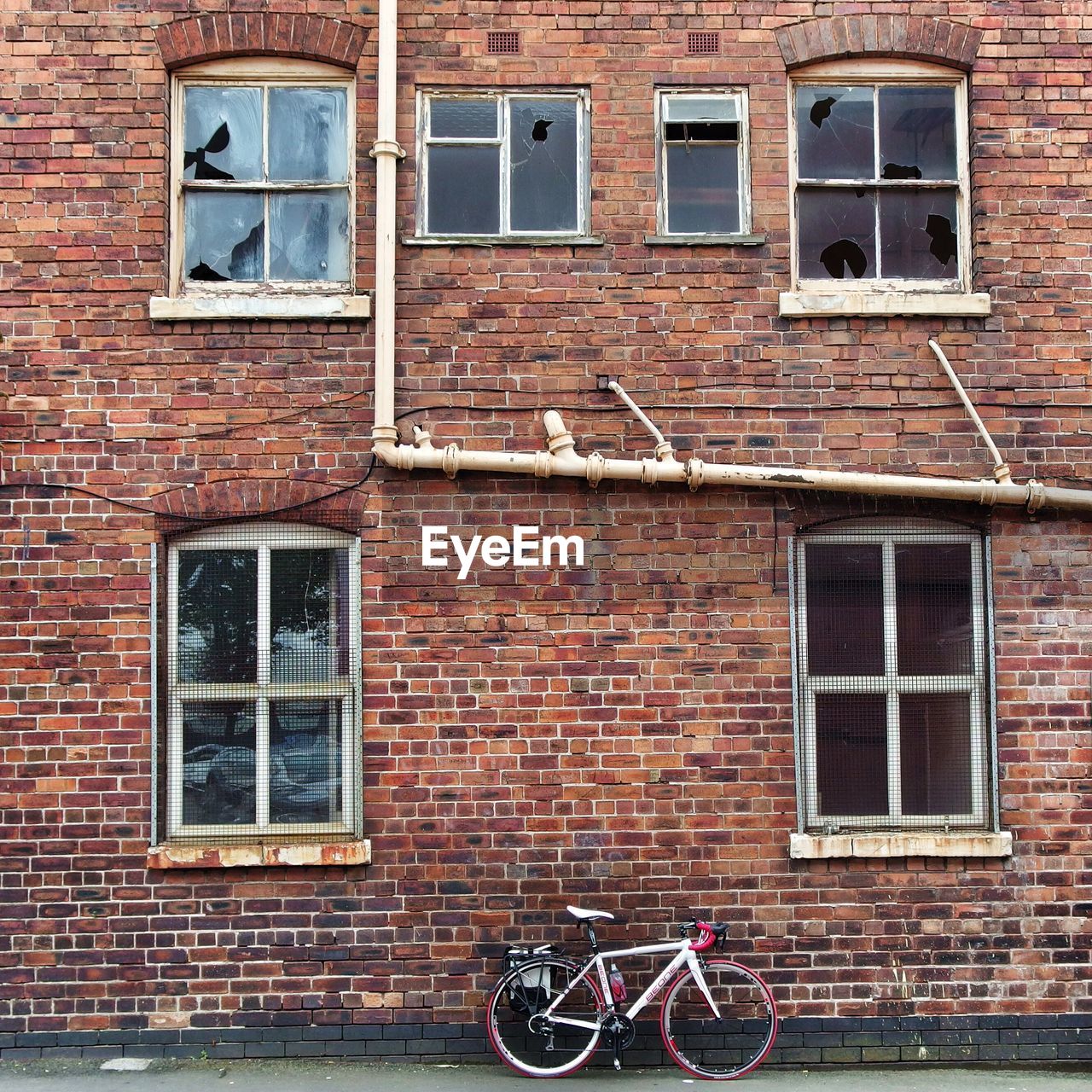 Bicycle leaning on wall of abandoned residential building