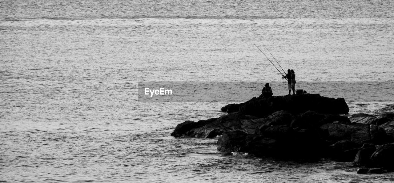 Panoramic view of people fishing in sea