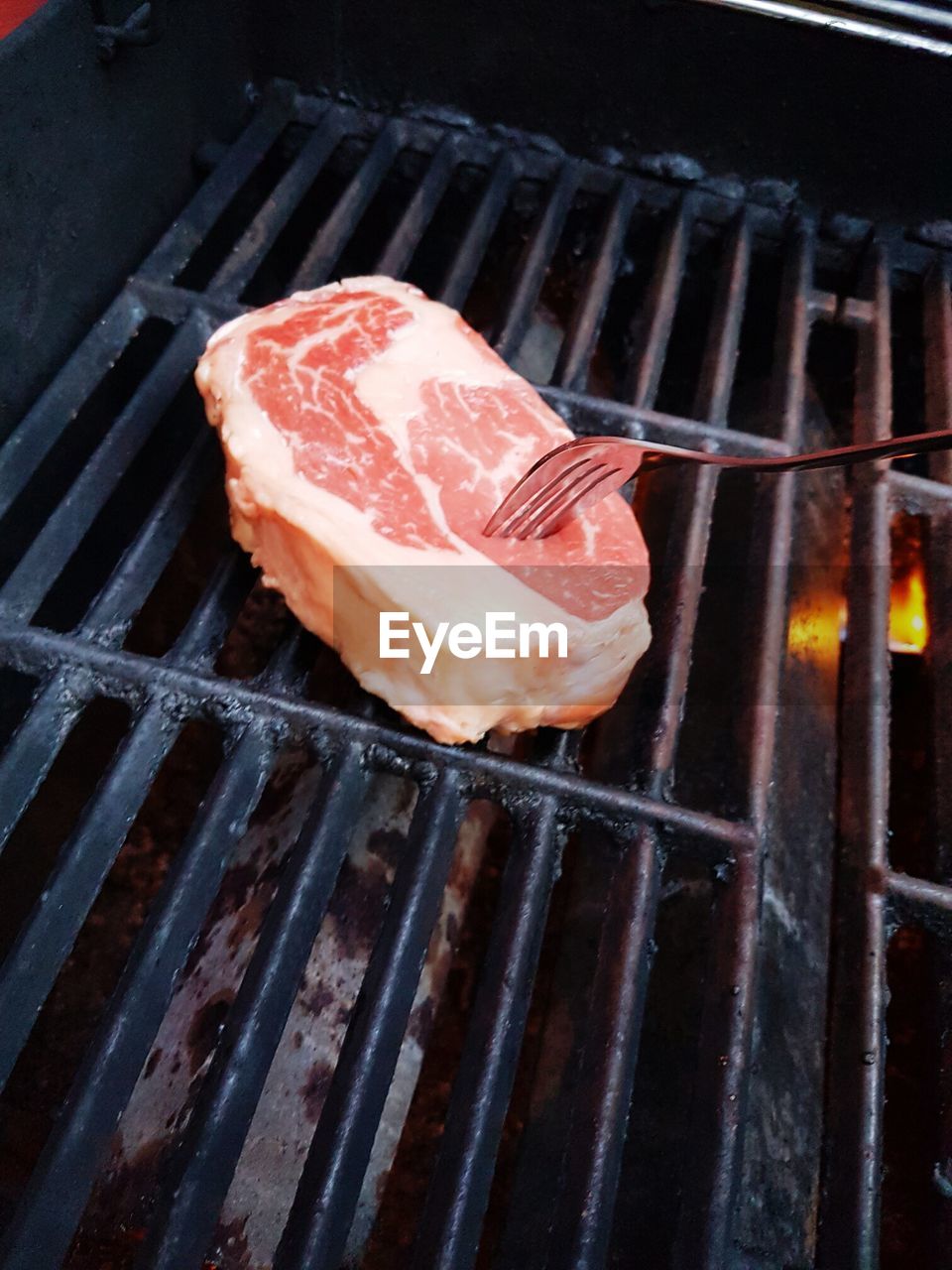 Close-up of beef with fork on barbecue grill