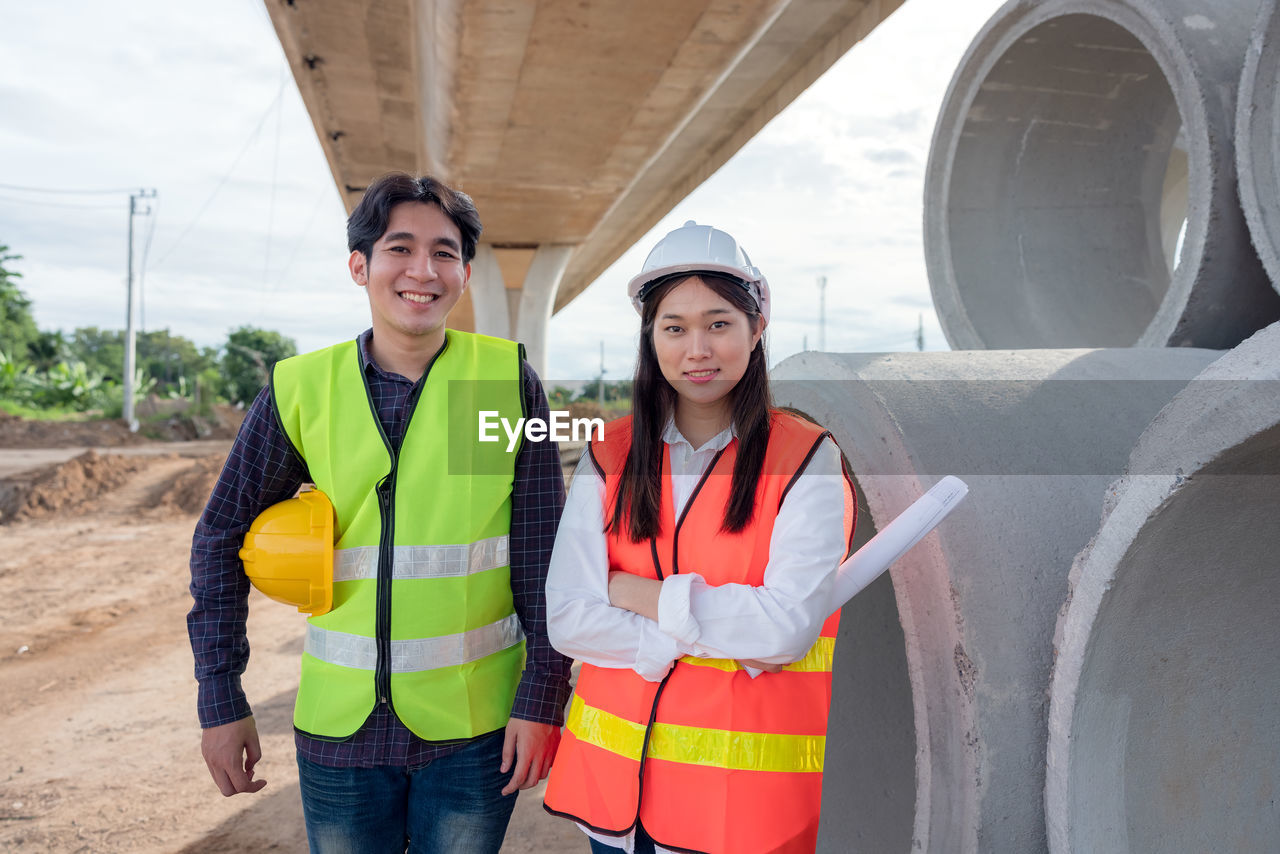 Portrait of a smiling young woman standing at construction site