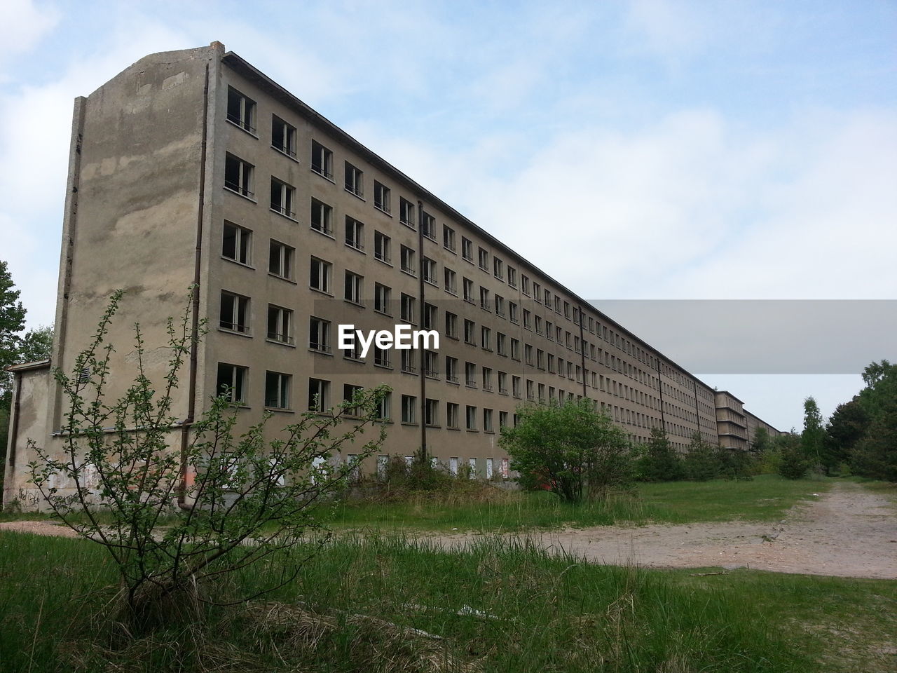 Abandoned building against cloudy sky