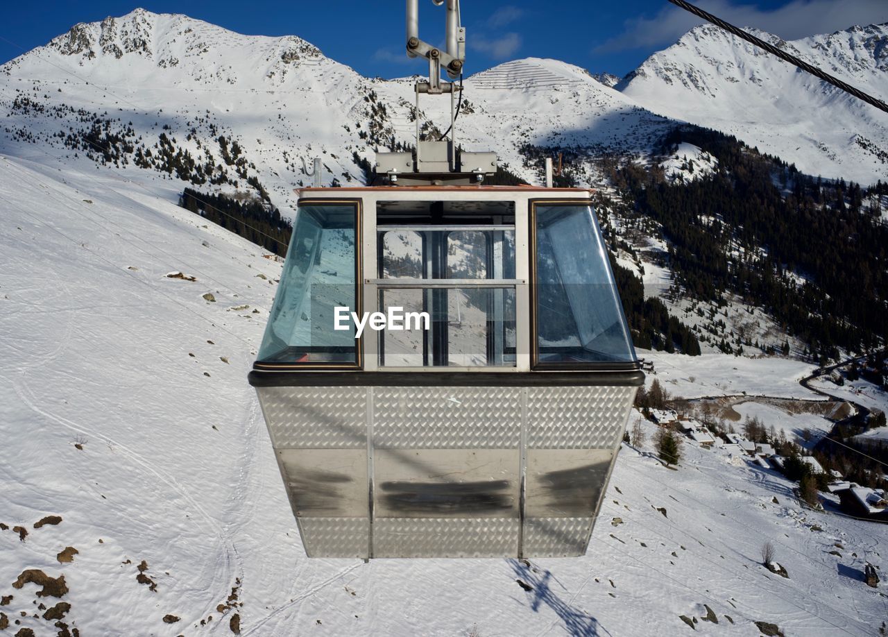 Cabin of cable car against snow covered mountain