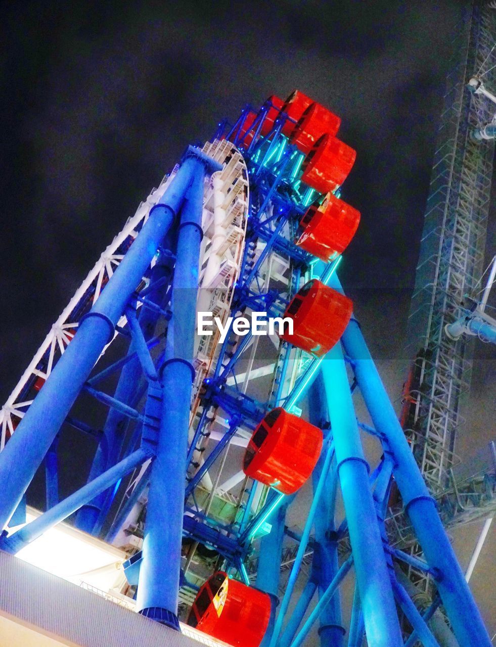 LOW ANGLE VIEW OF ROLLERCOASTER AGAINST SKY AT NIGHT