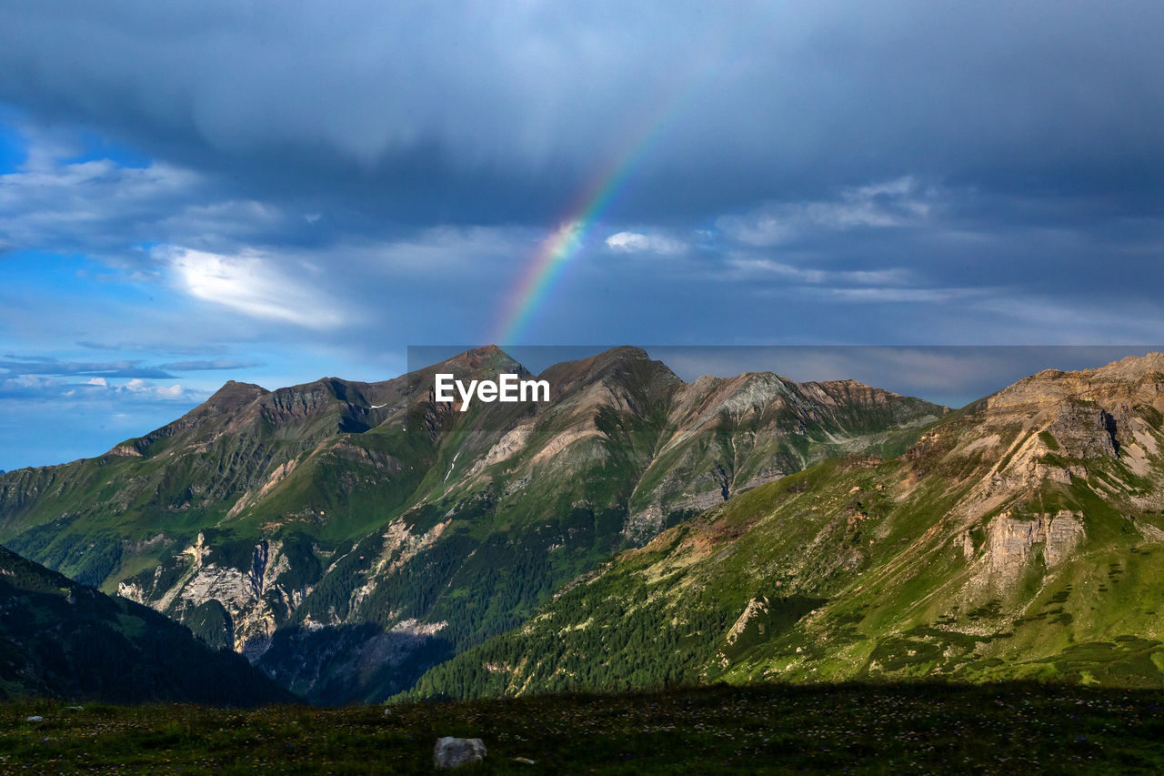 Scenic view of rainbow over mountains against sky