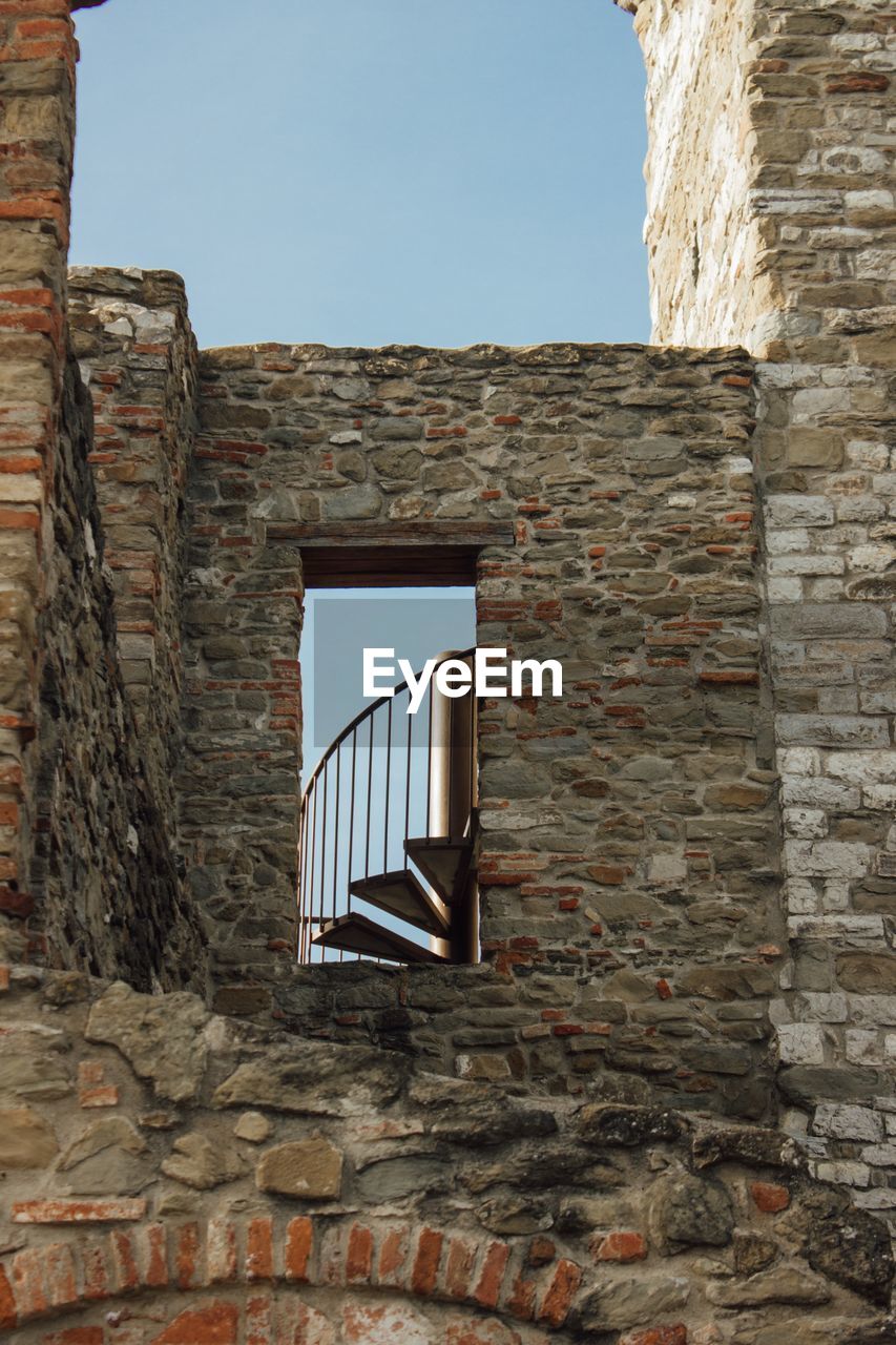 Low angle view of old medieval building with stairs against clear sky