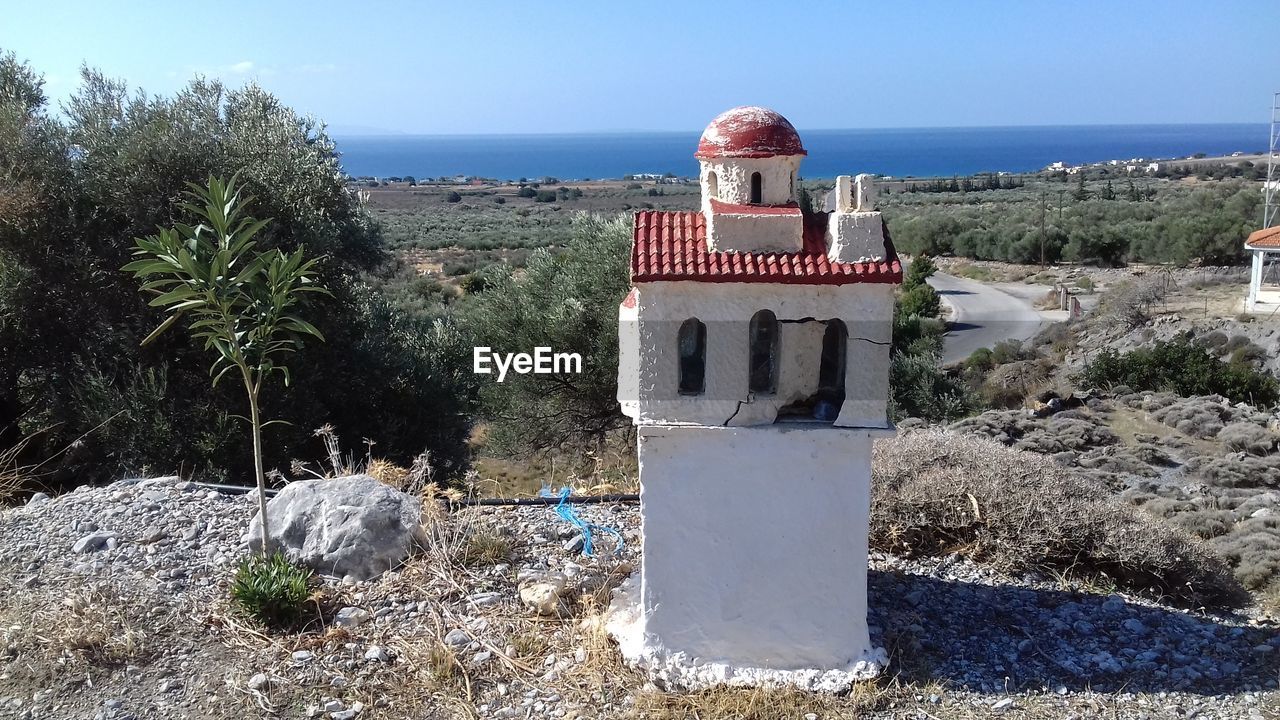 Built structure by sea against sky