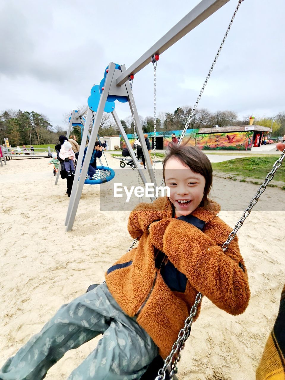 smiling, happiness, playground, one person, swing, women, nature, emotion, fun, childhood, leisure activity, enjoyment, sky, child, outdoor play equipment, female, day, adult, rope, portrait, smile, teeth, cheerful, sunlight, lifestyles, cloud, land, casual clothing, outdoors, looking at camera, clothing, holding, carefree, person, joy, sitting, trip, vacation, holiday, sand, positive emotion, beach, full length, young adult