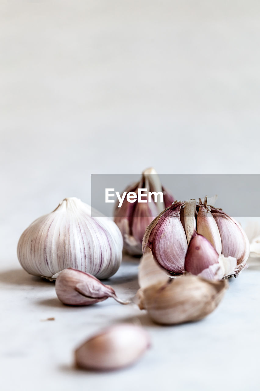 CLOSE-UP OF GARLIC AGAINST WHITE BACKGROUND