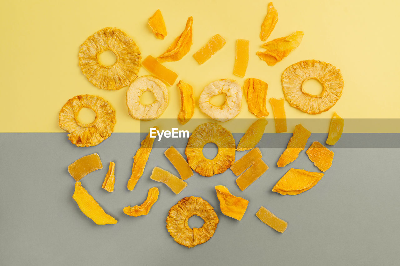 Assorted fruit jerky on yellow and gray background, top view, horizontal orientation