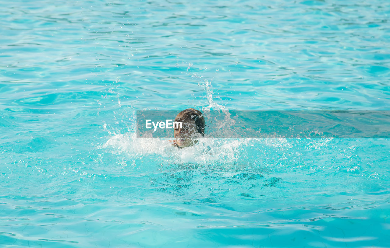 water, swimming, sports, swimming pool, water sports, one person, motion, nature, lifestyles, recreation, waterfront, day, individual sports, leisure activity, men, sea, blue, outdoors, splashing, child, high angle view, swimmer, one animal, childhood, enjoyment, rippled, azure, refreshment