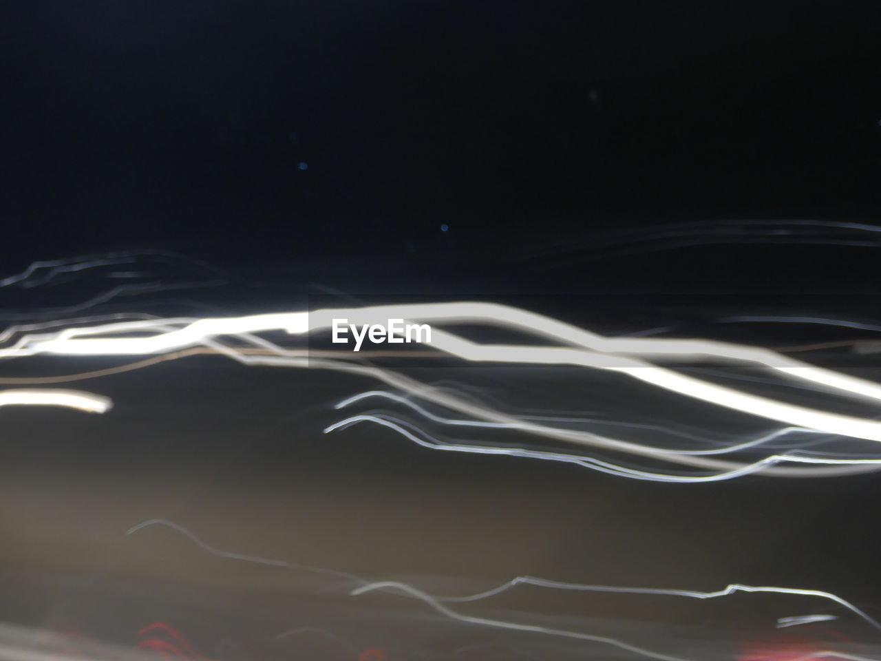 ABSTRACT IMAGE OF ILLUMINATED LIGHT AGAINST BLACK BACKGROUND