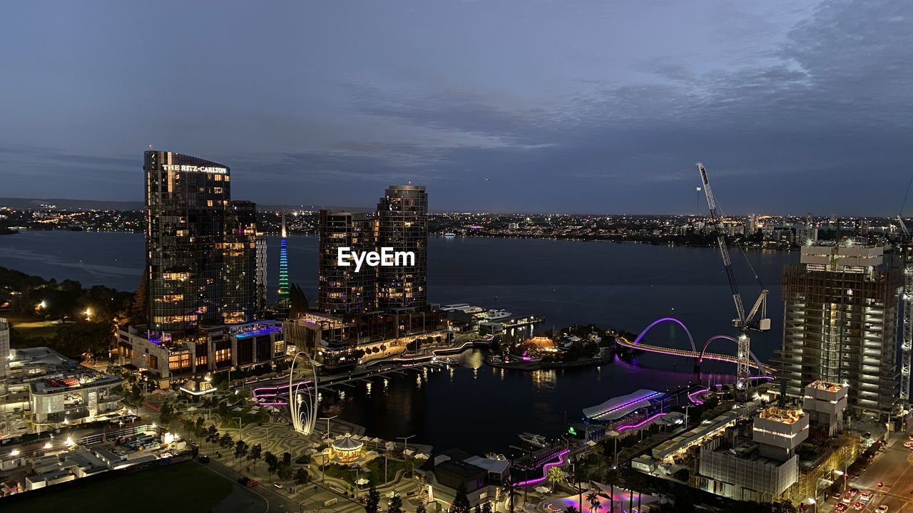 HIGH ANGLE VIEW OF ILLUMINATED CITY BUILDINGS AGAINST SKY