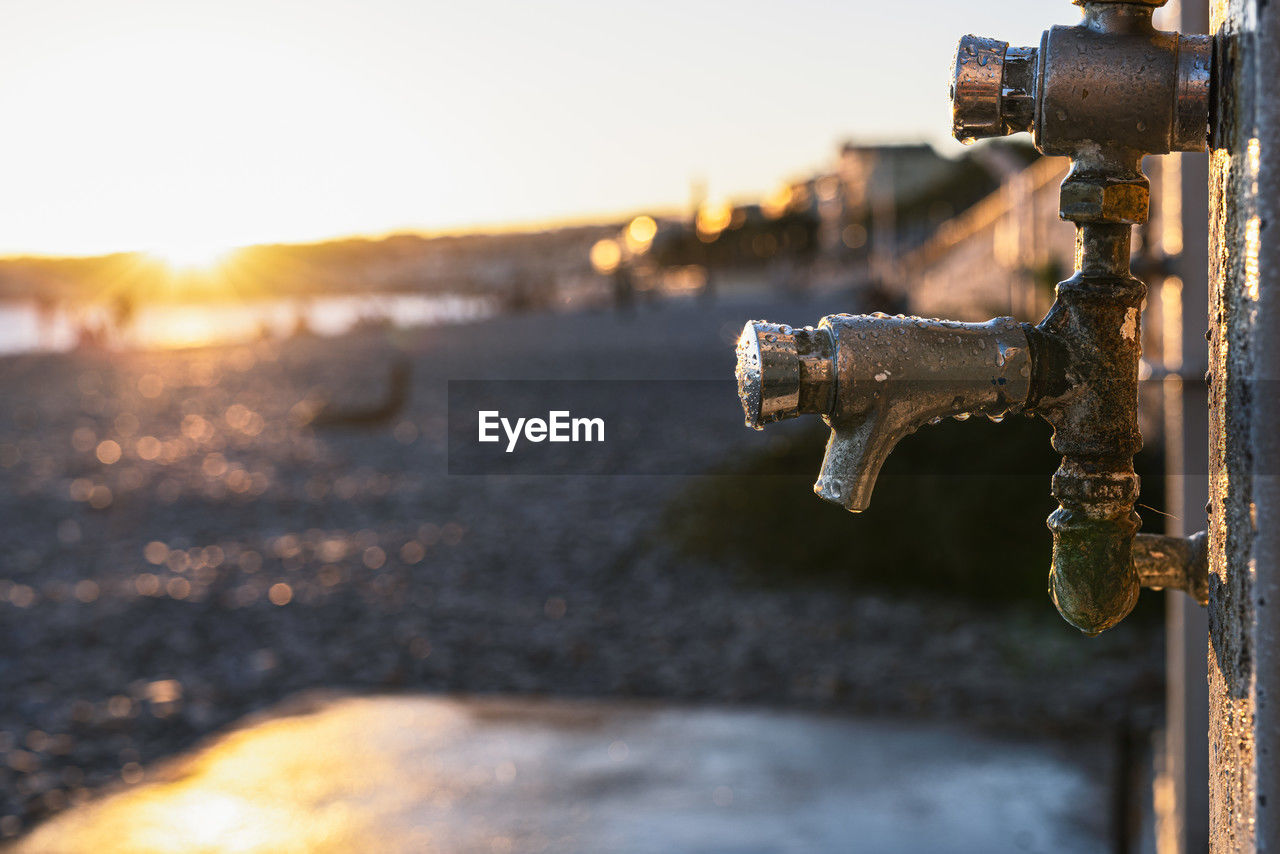 water, sky, nature, sunset, focus on foreground, sunlight, metal, no people, technology, close-up, outdoors, light