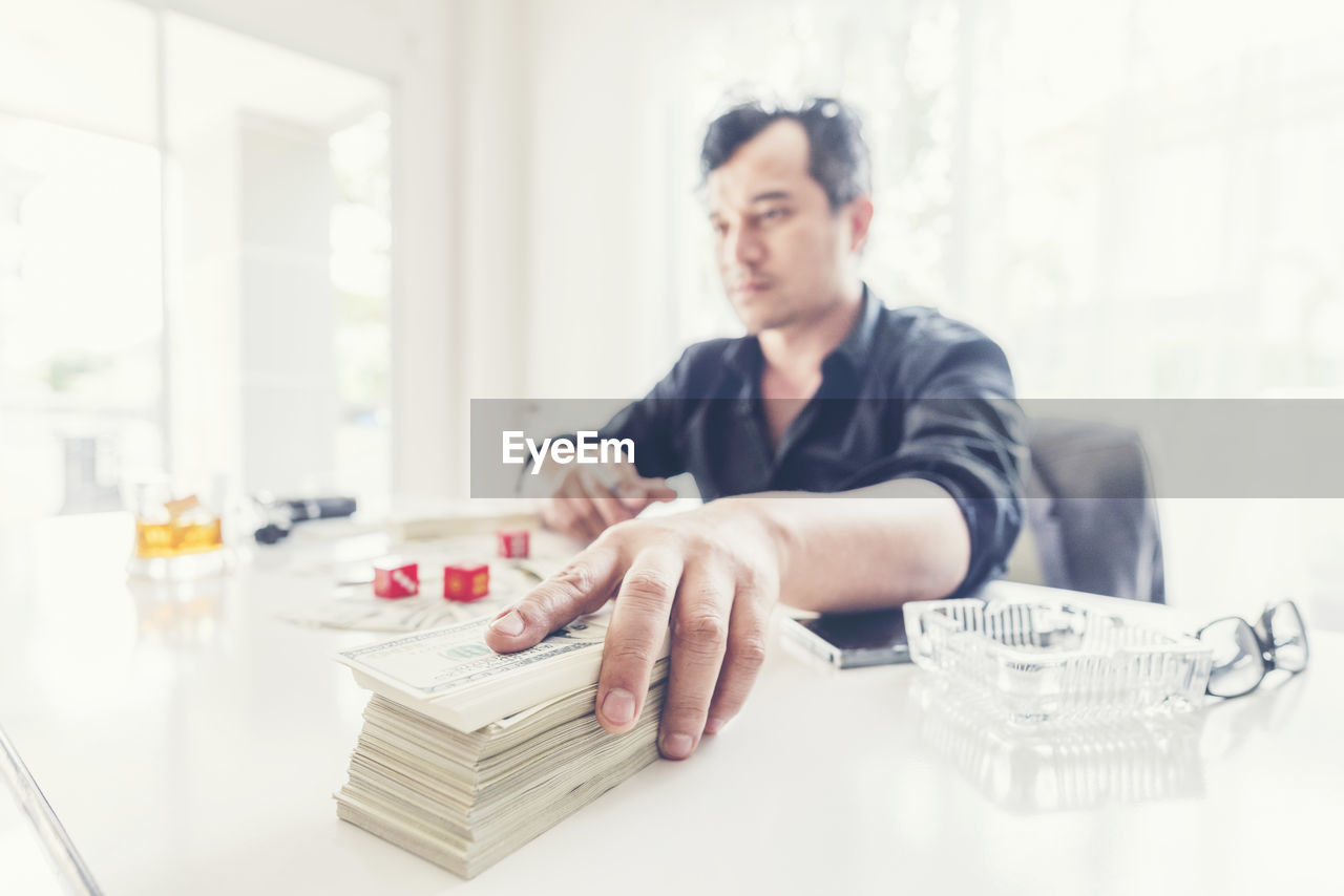 Man sitting with currency at table