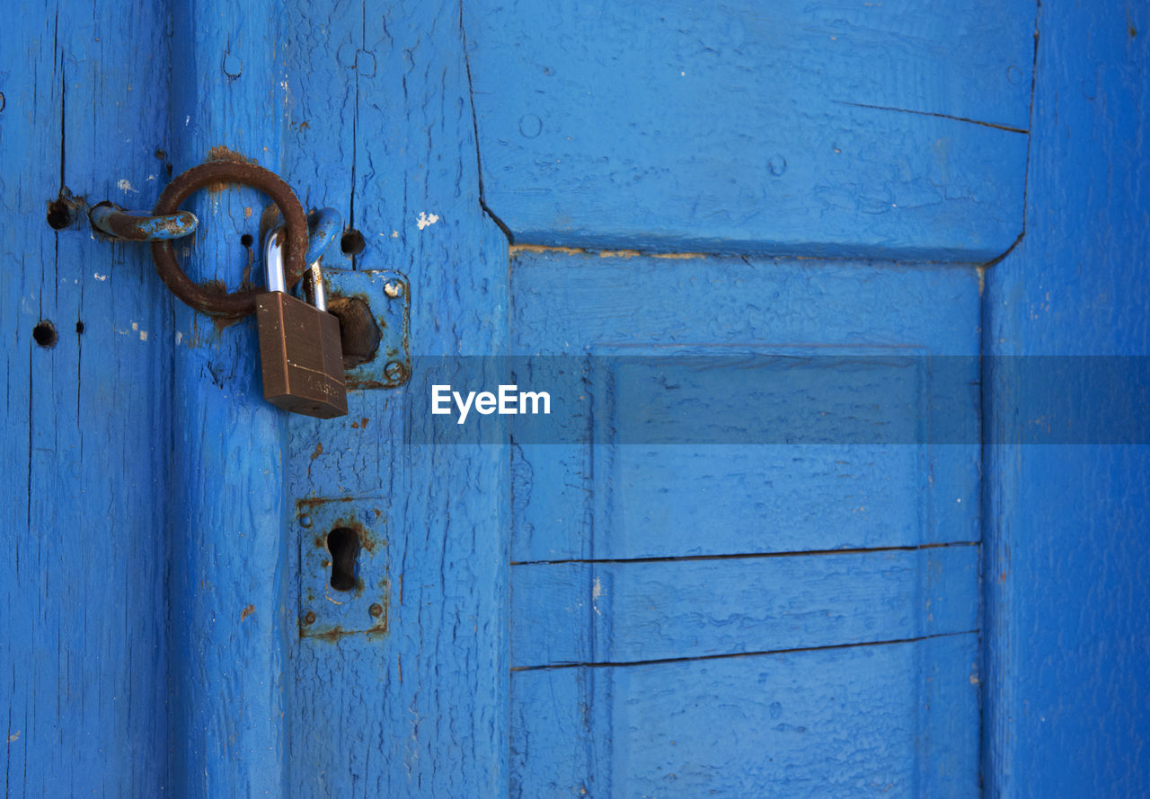 Close-up of old blue locked door