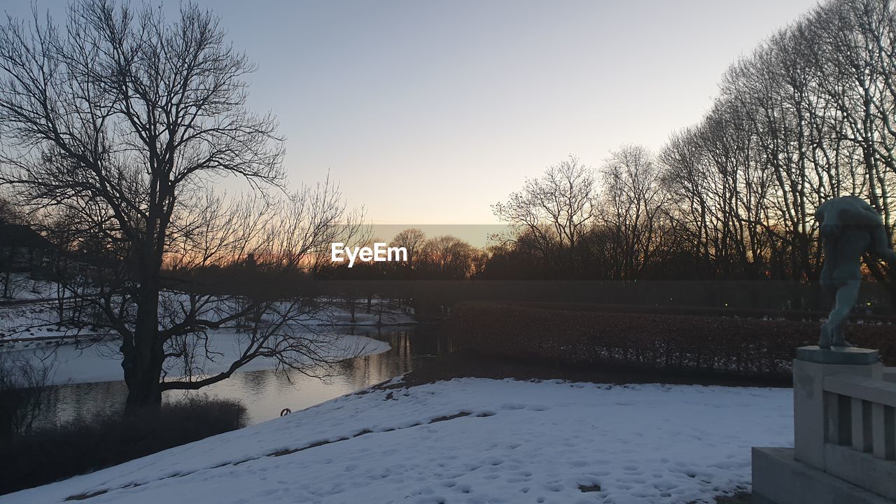 VIEW OF FROZEN LAKE AGAINST SKY DURING WINTER