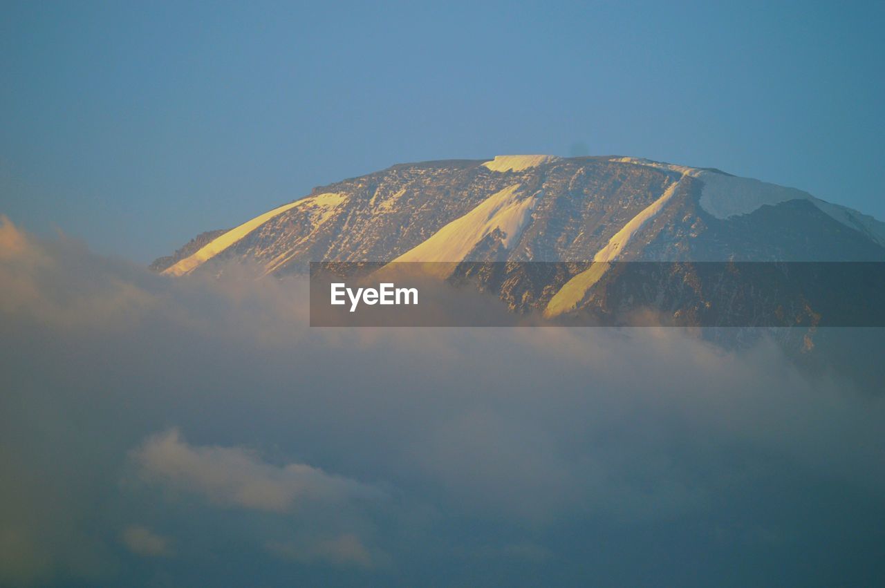 Mount kilimanjaro above the clouds seen from moshi town, tanzania