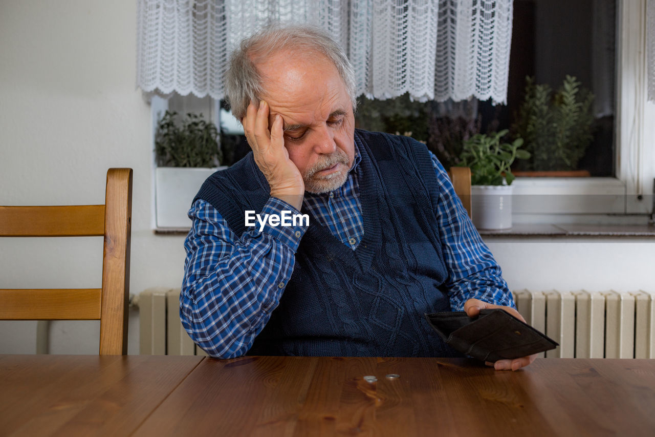 YOUNG MAN SITTING AT TABLE AT HOME