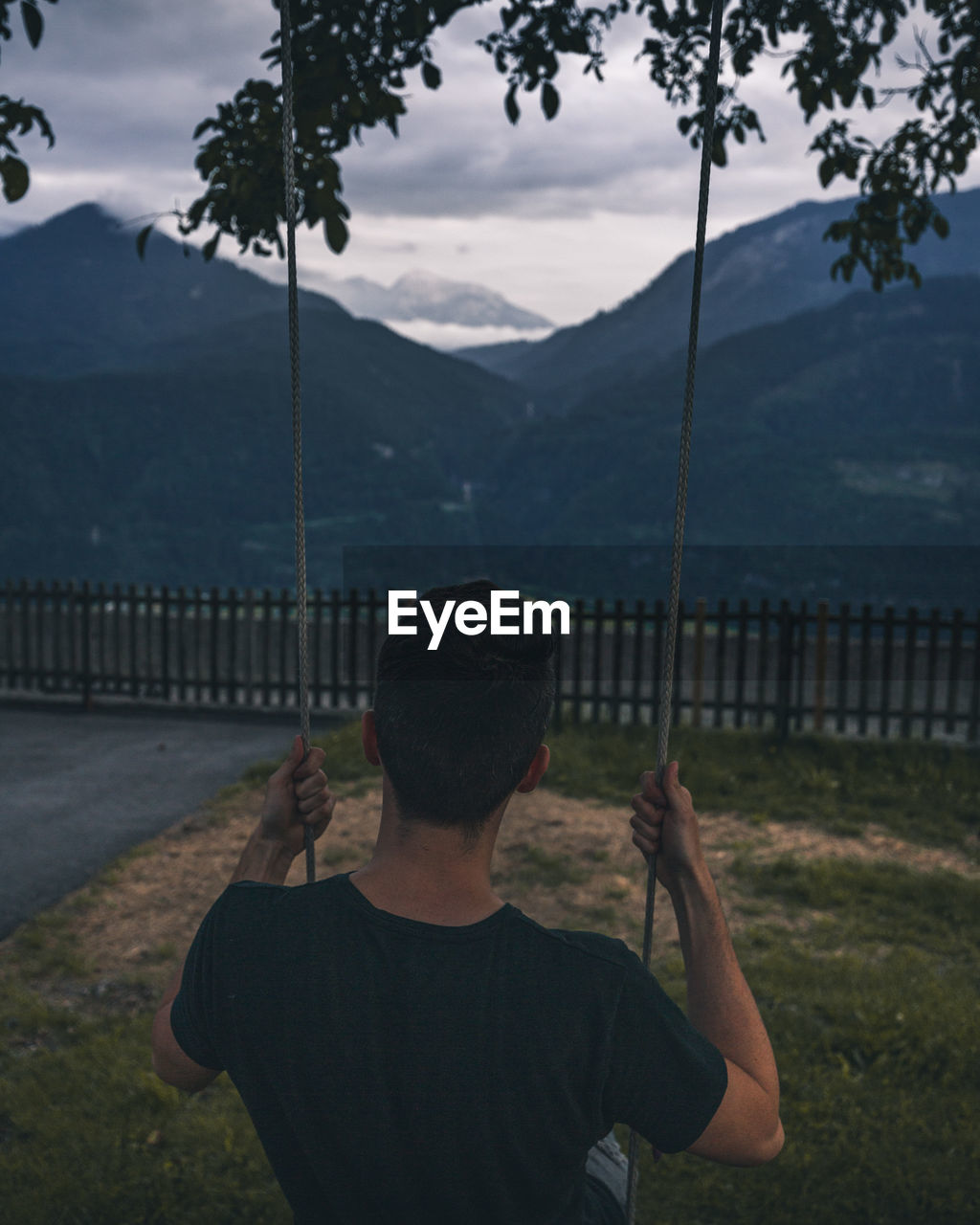 Rear view of man standing on mountain against sky