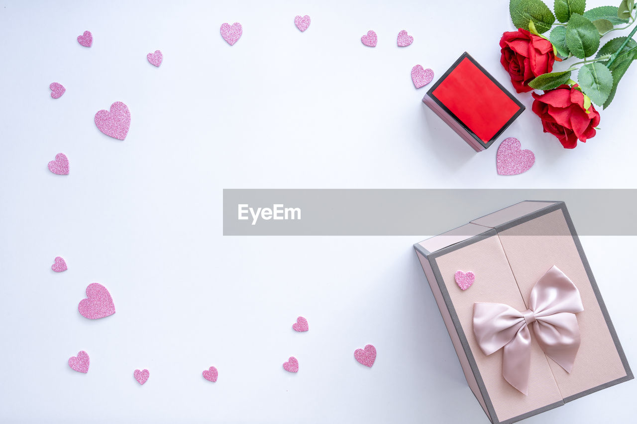 Beautiful valentine's day background with red hearts and roses on white banner background.