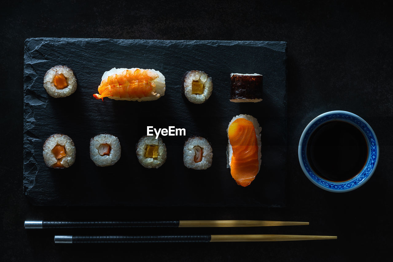 Close up healthy traditional japanese sushi set nigiri and rolls with chopsticks.