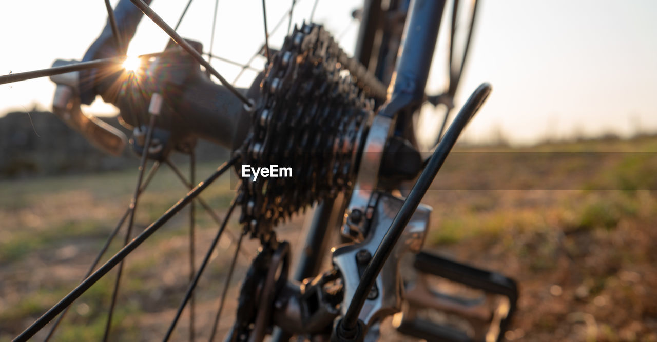 CLOSE-UP OF BICYCLE PARKED ON FIELD