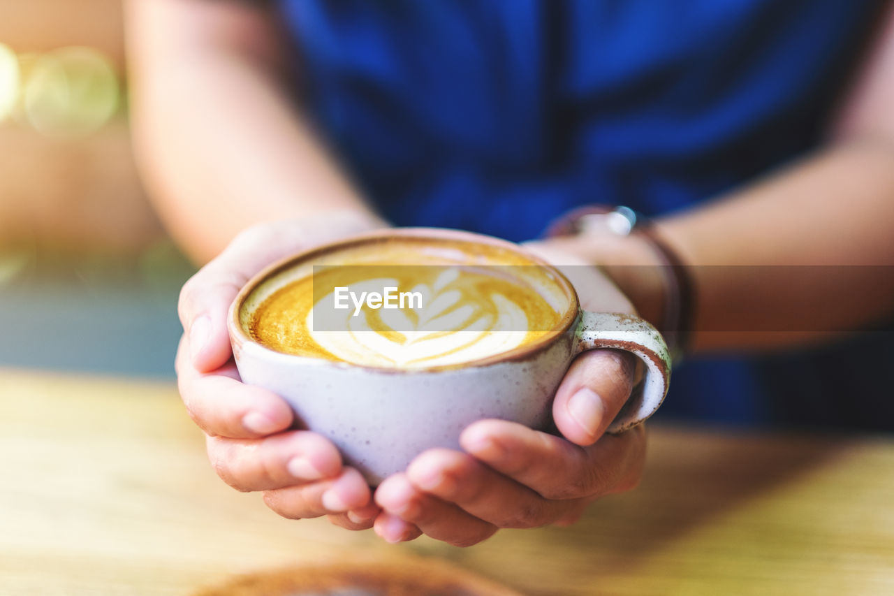 Close-up of hand holding coffee cup