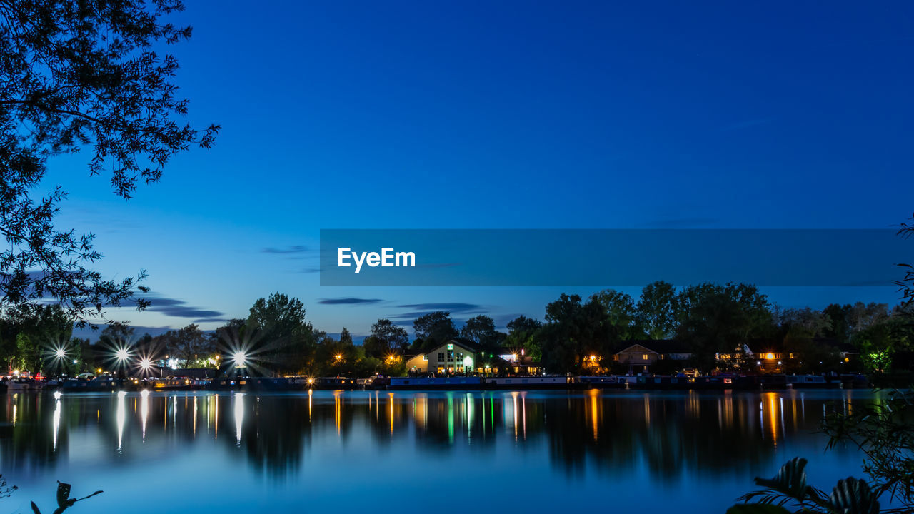 Scenic view of lake against blue sky at dusk