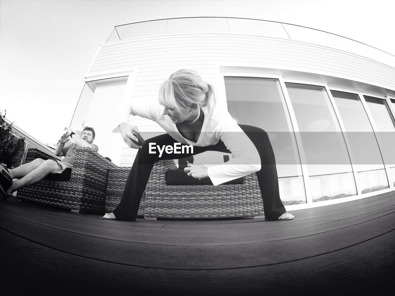 Low angle view of woman taking selfie while exercising against house