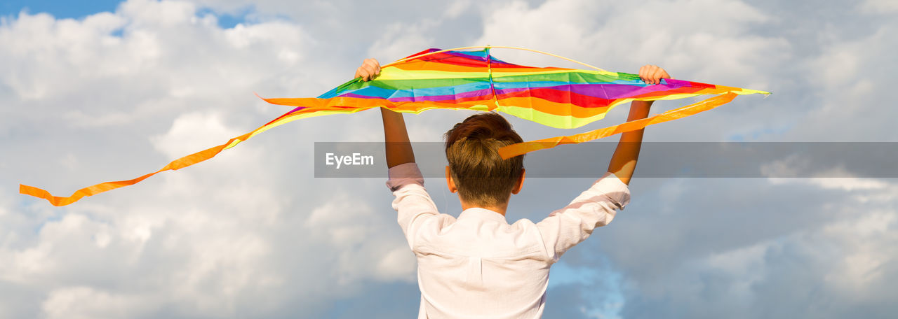 Portrait of a child 8-9 years old with a kite. a blond boy stands and looks into the distance 