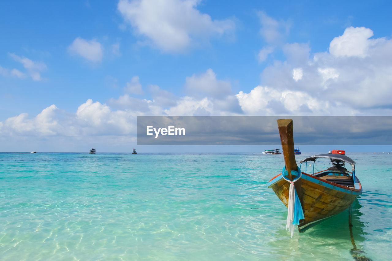 Fishing boat in sea against sky