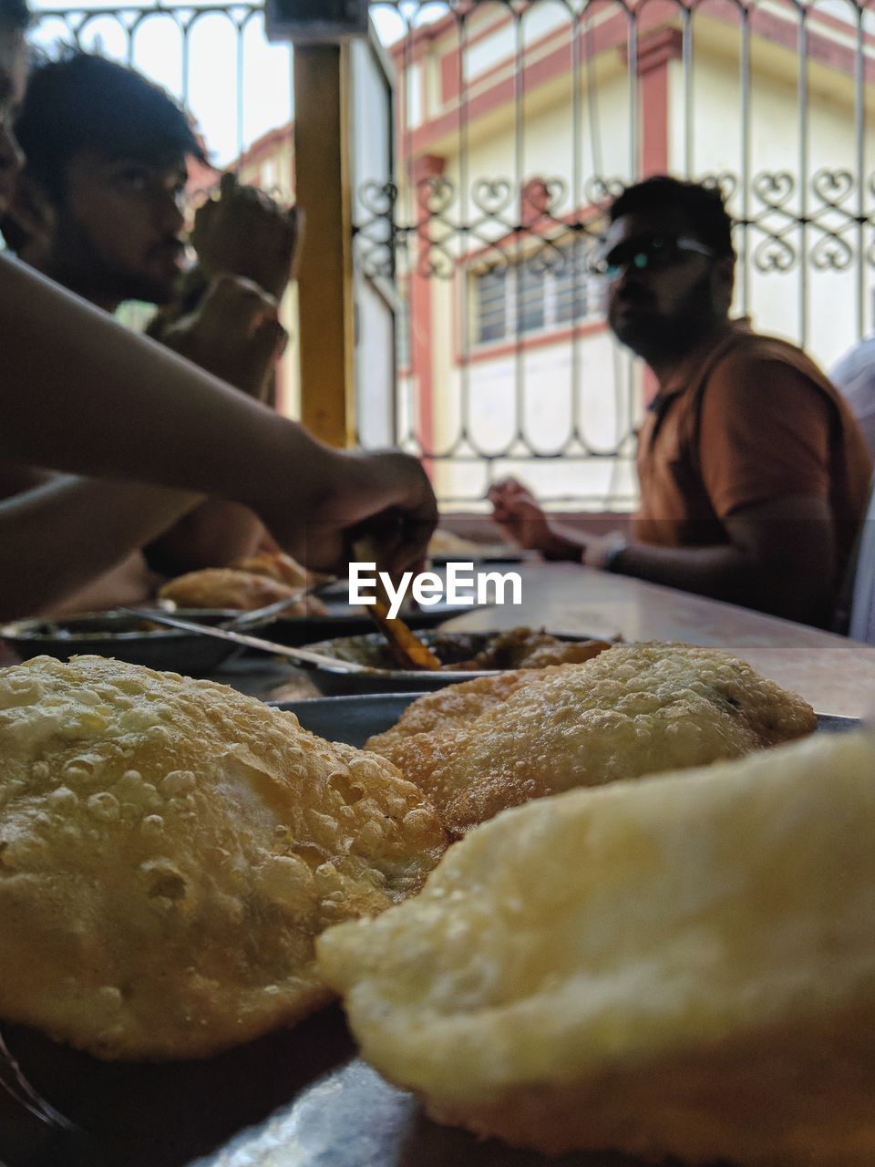 Close-up of food on table with people